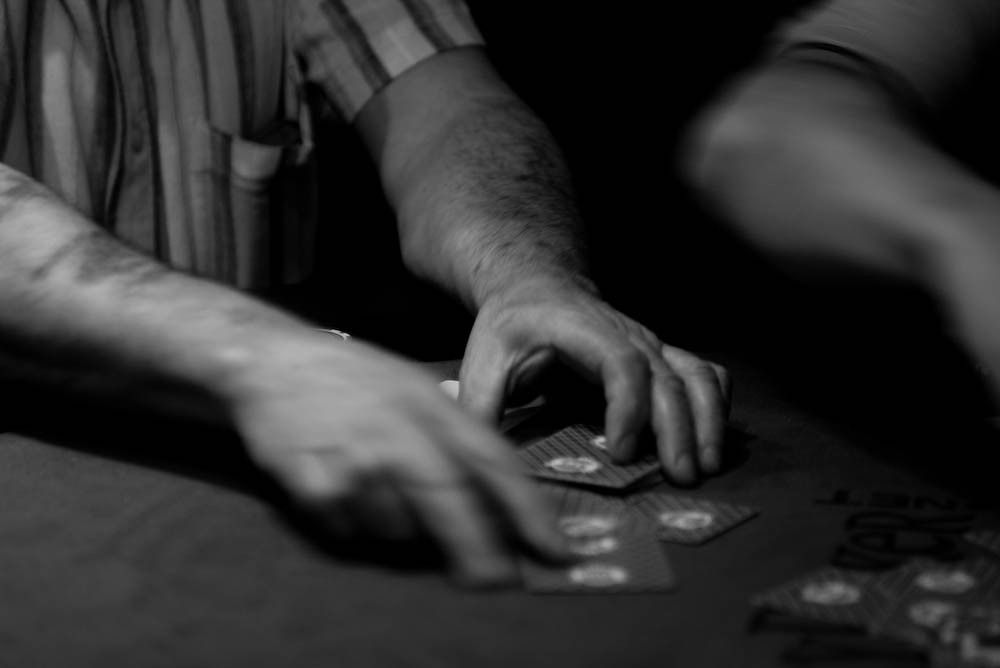 Hands dealing cards at a card table